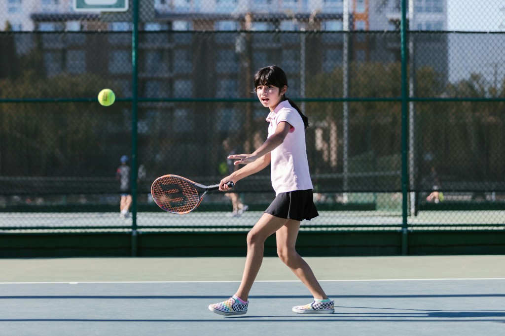 Child learning tennis forehand