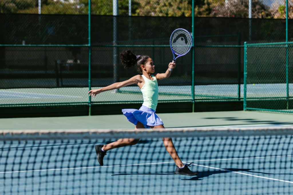 Young student running on tennis court