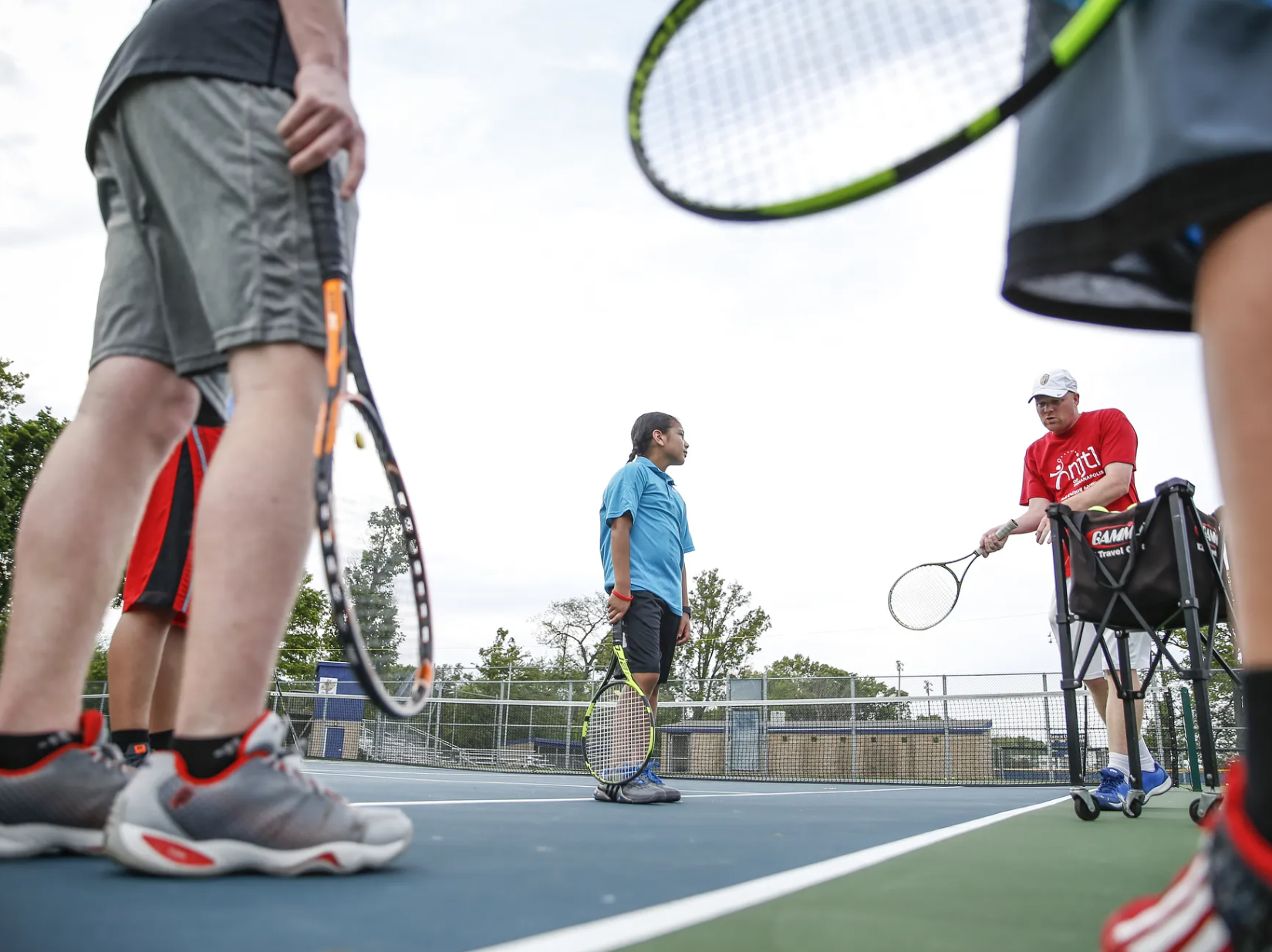 group of students taking a tennis lesson in indianapolis